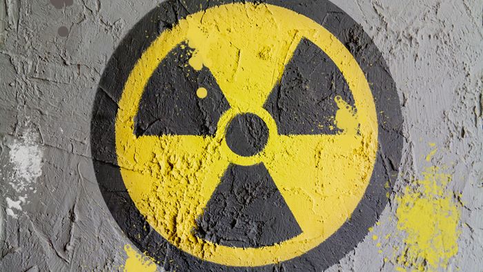 Das gelb-schwarze Symbol für radioaktive Strahlung ist auf eine Mauer gesprayt worden.