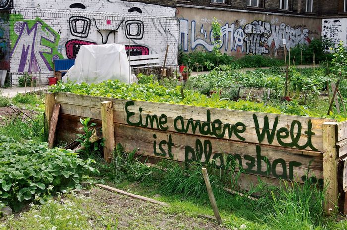 Ein Urban Gardening Hochbeet mit der Aufschrift "Eine ander Welt ist pflanzbar"