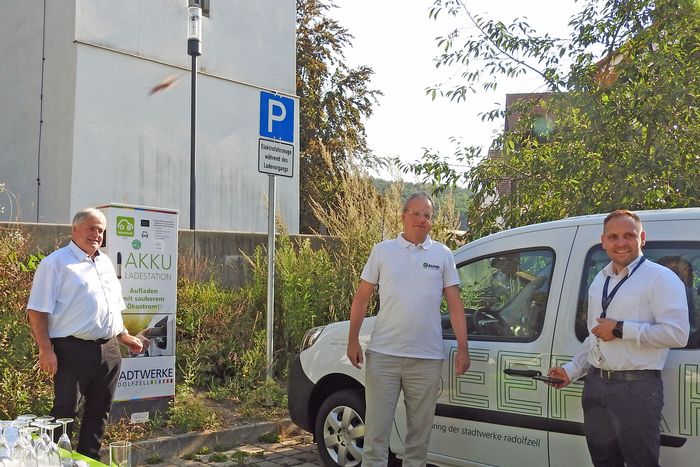 Hauptgeschäftsführer Ralf Stolz steht vor einem E-Auto.