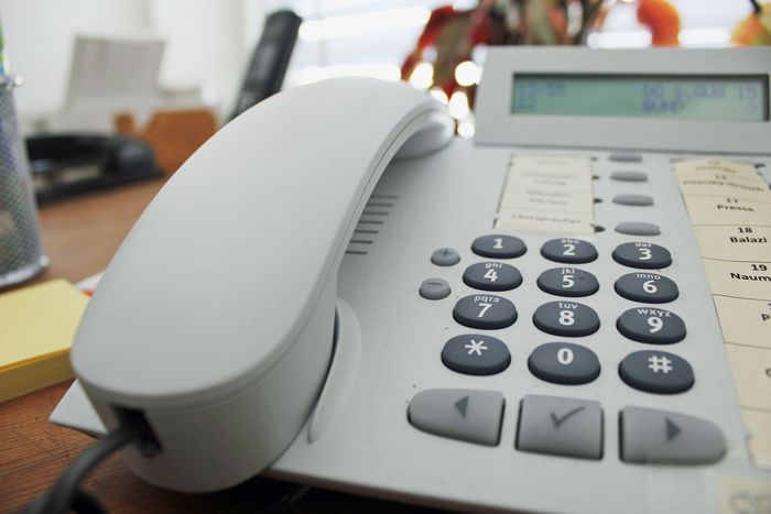 Ein Büro-Telefon auf einem Holztisch.