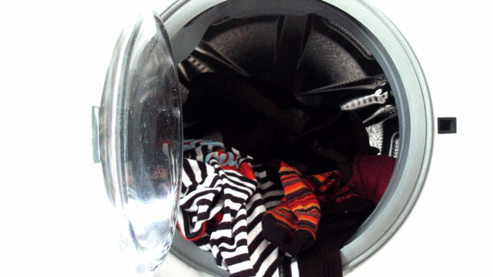 Eine Waschtrommel voller Kleider.