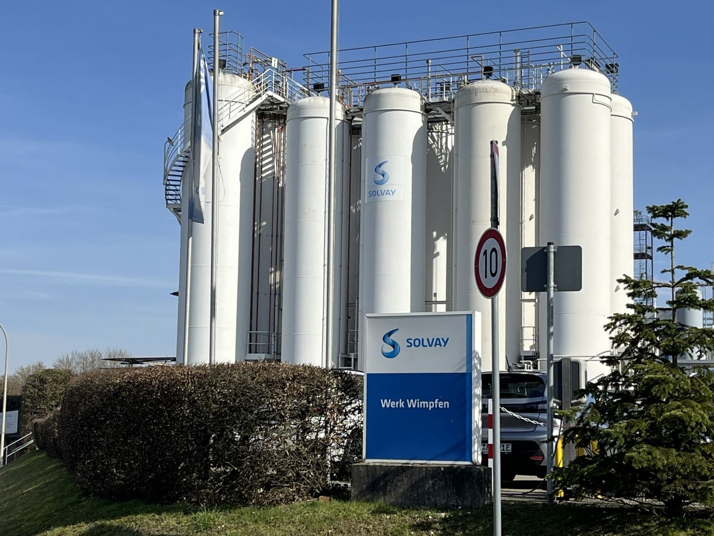 Solvay-Werk in Bad Wimpfen, Werk-Schild mit Beschriftung "Solvay Werk Wimpfen" und weißen Kühltürmen im Hintergrund