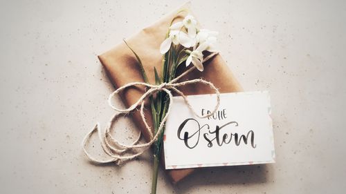 Ein Päckchen mit einer Karte mit der Aufschrift "Frohe Ostern" auf weißem Untergrund.