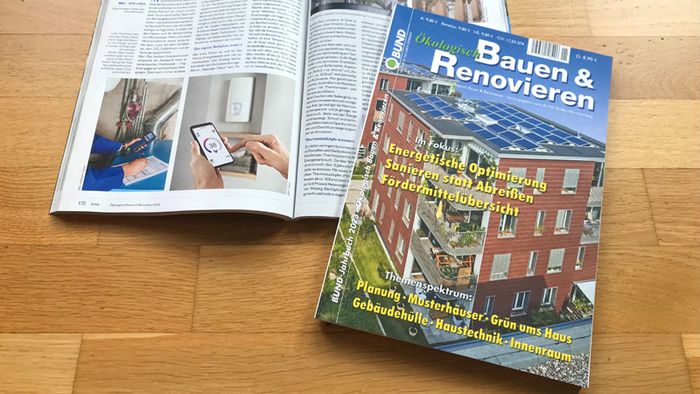 Das "BUND-Jahrbuch Bauen und Renovieren" liegt auf einem Holztisch.