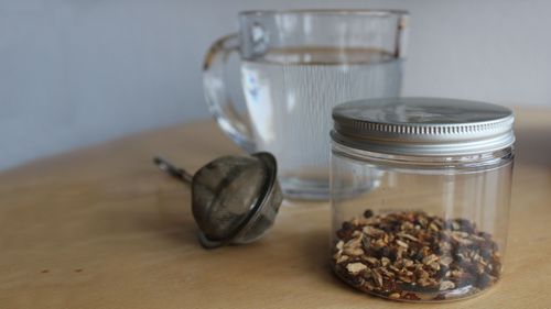 Eine Tasse heißes Wasser und Teepulver im Schraubglas