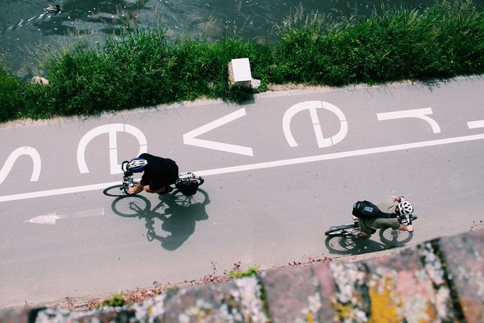 Blick aus der Vogelperspektive auf einen Radweg mit zwei Radfahrern.