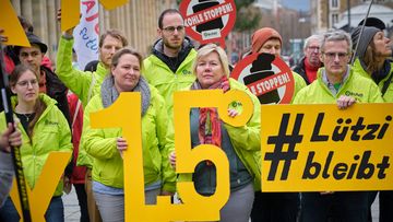 Aktive vom BUND haben ein Schild mit einer "eins komma fünf" in der Hand.
