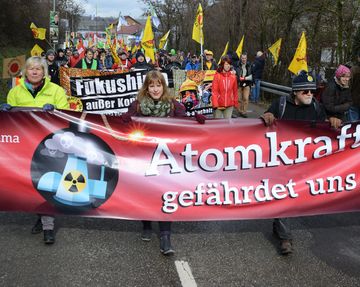 Frauen und Männer demonstrieren in Neckarwestheim gegen Atomkraft.