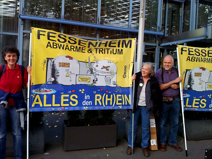 BUND-Aktive protestieren mit Plakaten für eine Abschaltung des Atomkraftwerks Fessenheim.