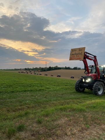 Traktoren fahren mit Schildern um merhrere Felder