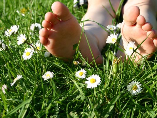 Füße liegen im Gras