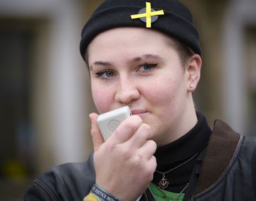 Eine junge Frau spricht in ein Megafon.
