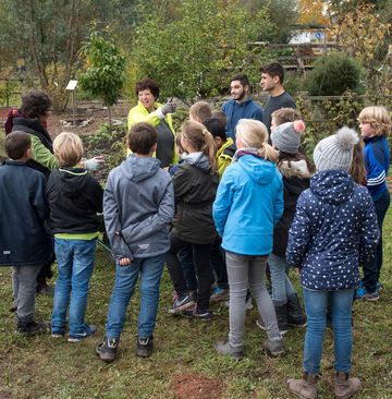 Ursula Zeeb ist mit einer Kindergruppe in einem Eidechsengarten.