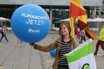 Kreisgeschäftsführerin Silvia Adler hät einen Ballon mit der Aufschrift "Klimaschutz jetzt!"