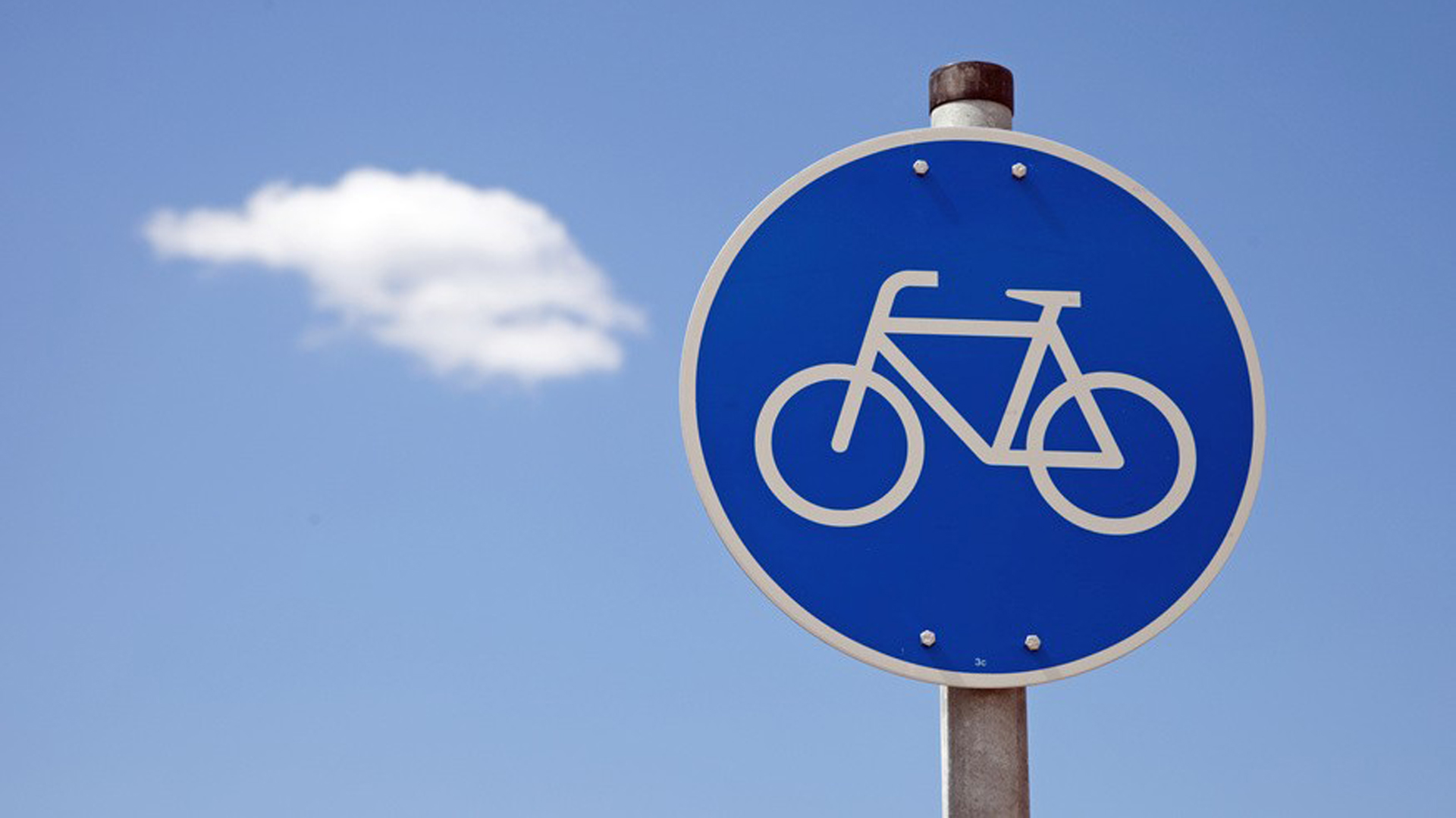 Ein blaues Fahrrad-Verkehrsschild vor blauem Himmel