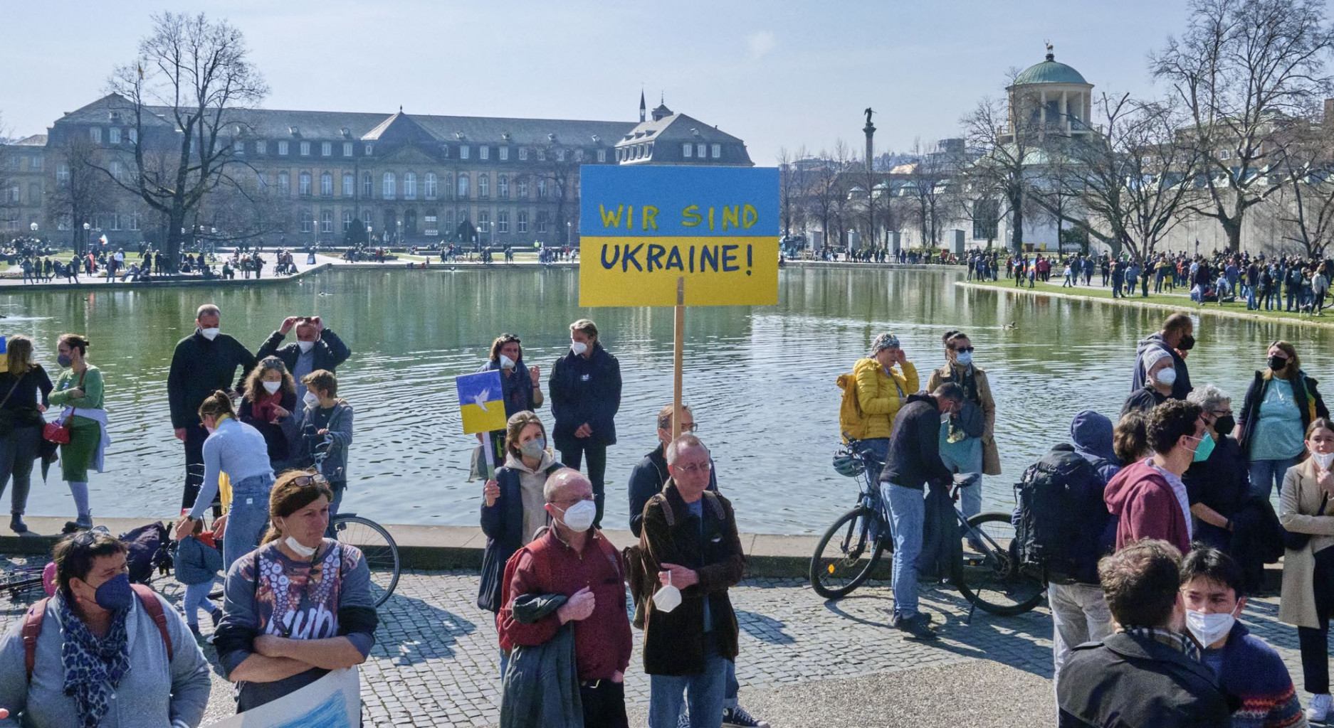 Demonstrierende stehen mit einem "Wir sind Ukraine" Schild um den Eckernsee in Stuttgart. 