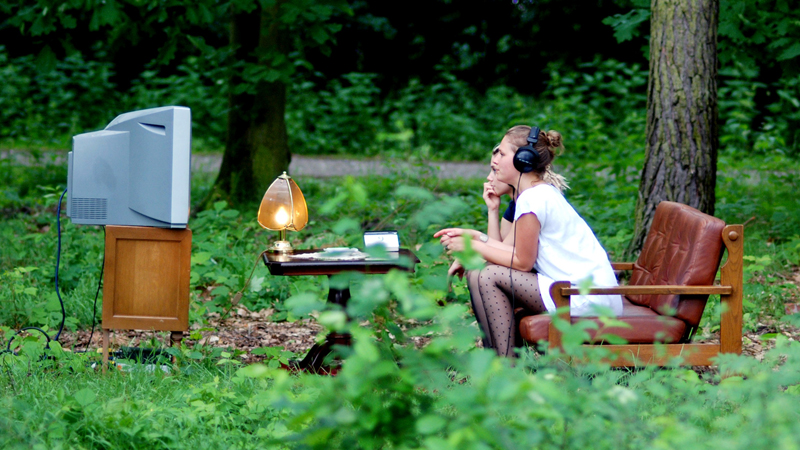 Zwei Mädchen schauen in der Natur im Wald Fernsehen. Foto: mi.la/photocase.de