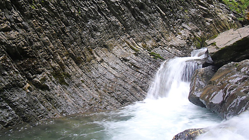 Ein kleiner Wasserfall zwischen Felsen.