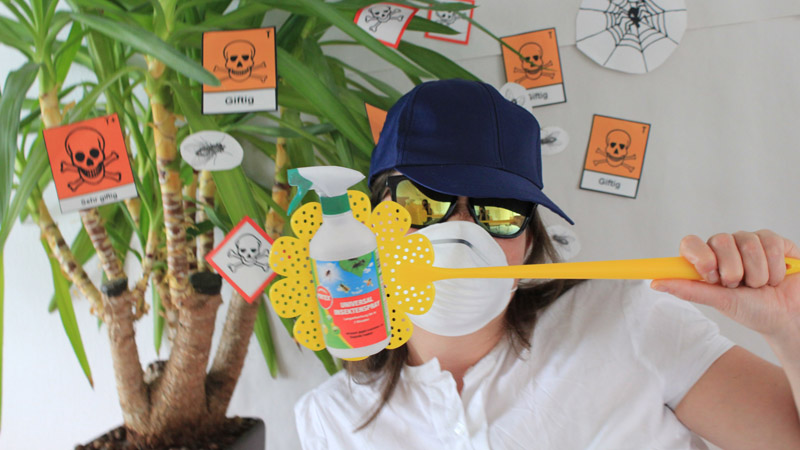 Eine Frau mit einer Schutzmaske und Fliegenklatsche wehrt Glyphosat und Pestizide ab.