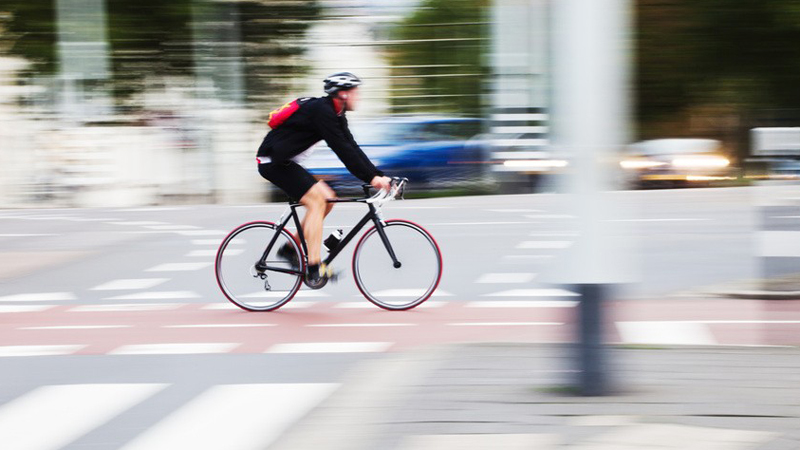 Ein Fahrradfahrer fährt in schnellem Tempo durch die Innenstadt.
