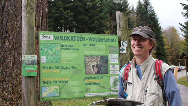 BUND-Naturschützer vor dem Schild des Wildkatzenpfades